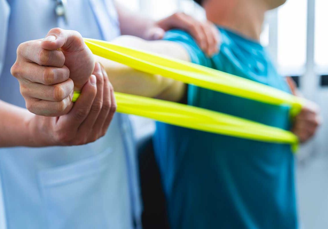 Man doing physical therapy with yellow resistance band.