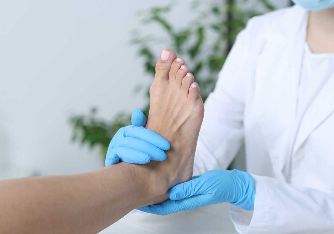 Podiatrist examining patients foot in clinic setting